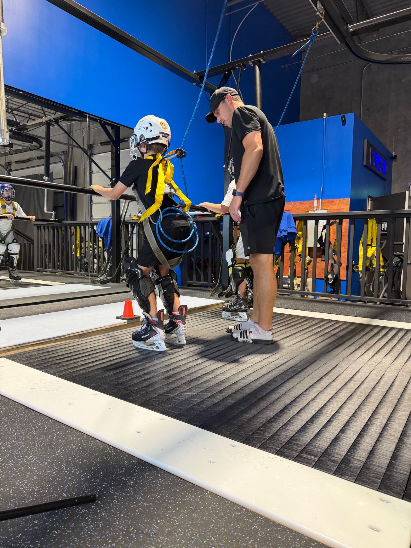 Coach guiding a player on the skating treadmill